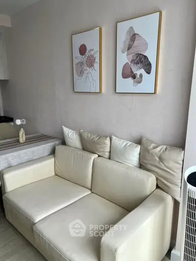 Cozy living room with elegant artwork and plush sofa, perfect for relaxation.