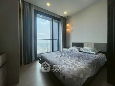 Modern bedroom with large window offering stunning city view, featuring stylish decor and ample natural light.
