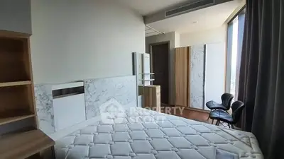 Modern bedroom with large window and stylish furniture in a high-rise apartment.
