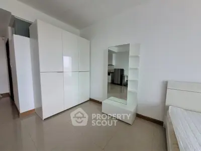 Spacious bedroom with modern white wardrobe and sleek mirror design