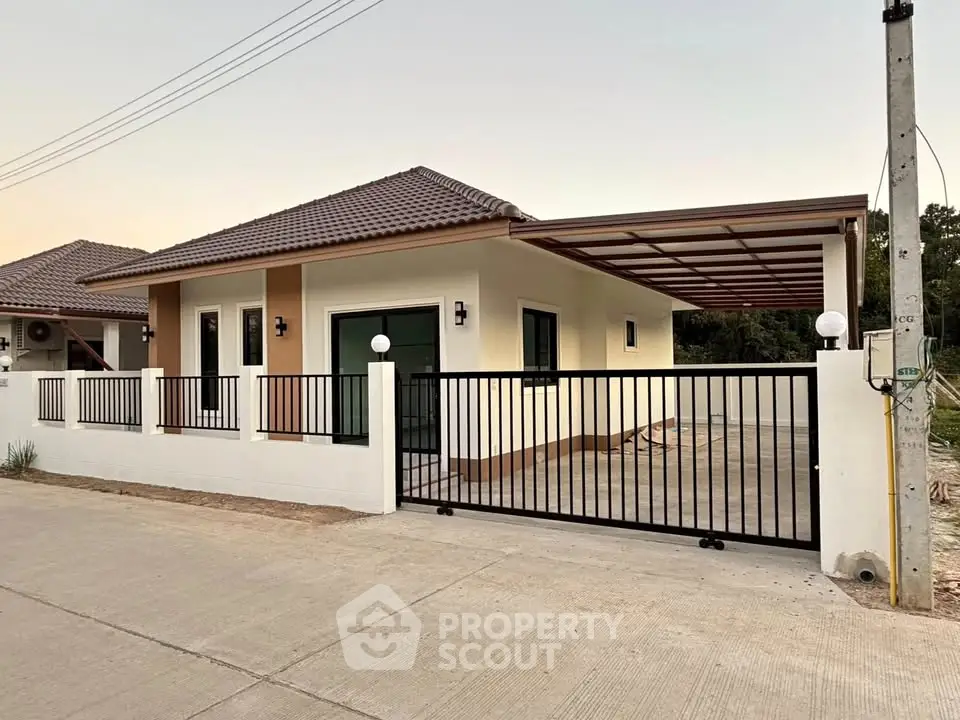 Modern single-story house with gated driveway and tiled roof