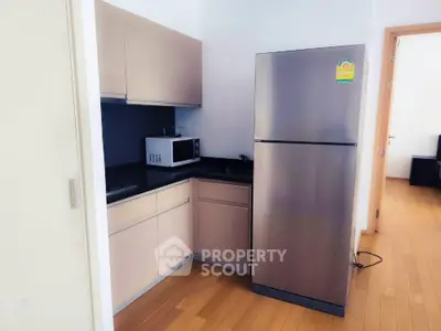 Modern kitchen with sleek stainless steel fridge and microwave in compact layout