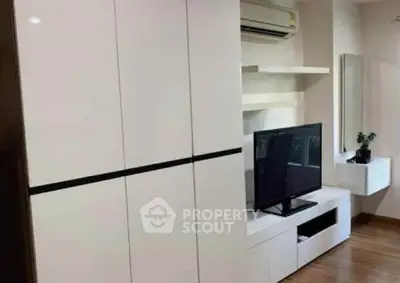 Modern living room with sleek white furniture and mounted TV