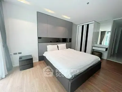 Modern bedroom with sleek design and ample natural light, featuring a comfortable bed and stylish furnishings.