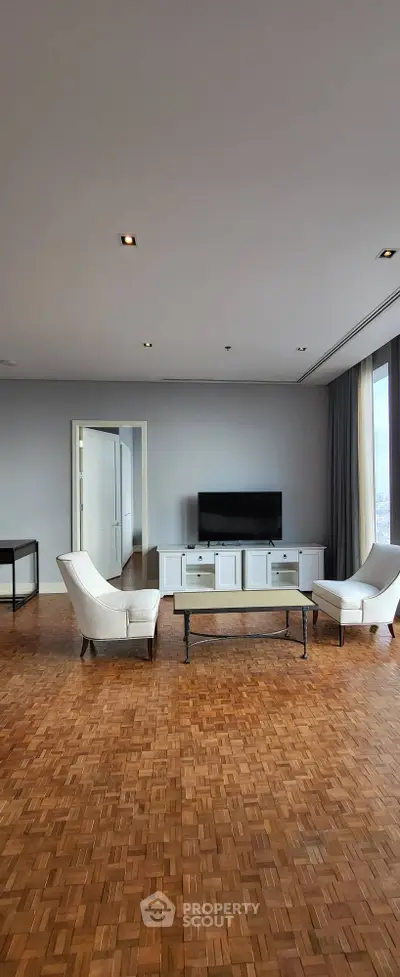 Spacious living room with parquet flooring and modern furniture, ideal for relaxation.