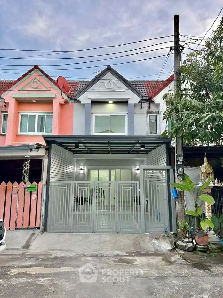 Charming townhouse with modern facade and gated entrance in a serene neighborhood.