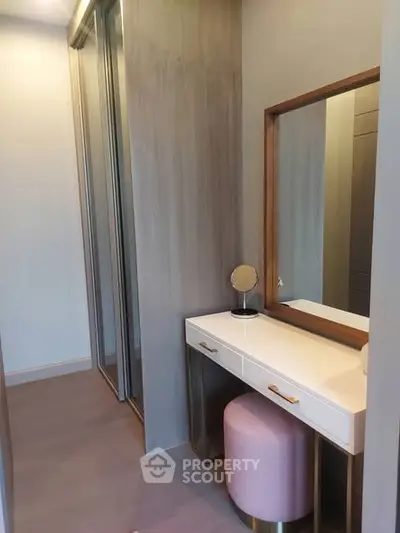 Elegant dressing area with mirror and stool in modern apartment