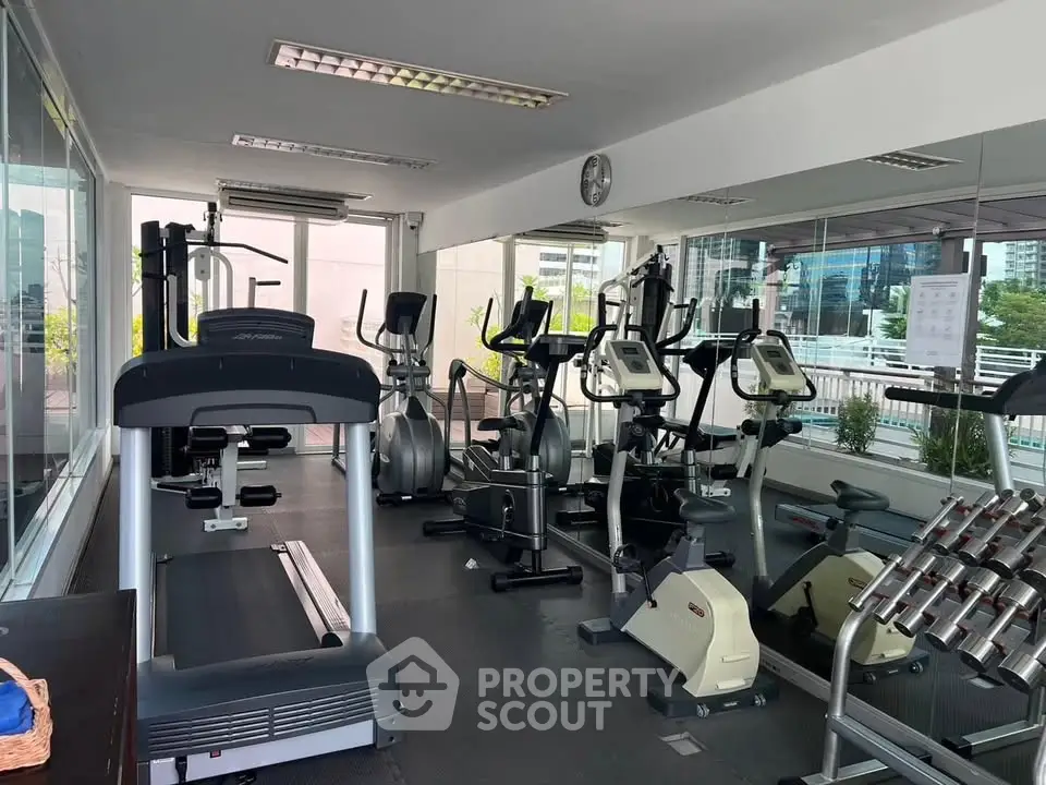 Modern gym with state-of-the-art fitness equipment and city view, perfect for active lifestyle enthusiasts.