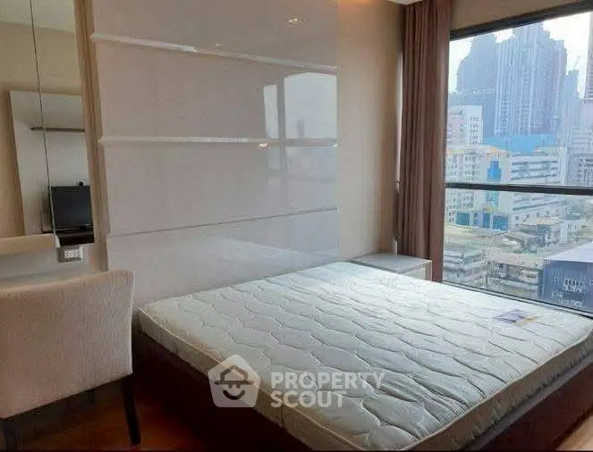 Modern bedroom with city view, featuring a comfortable bed and sleek design, perfect for urban living.