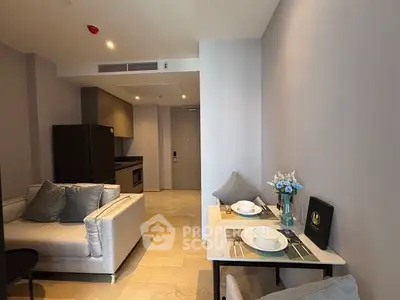 Modern apartment interior with cozy living area and dining setup, featuring sleek kitchen appliances.