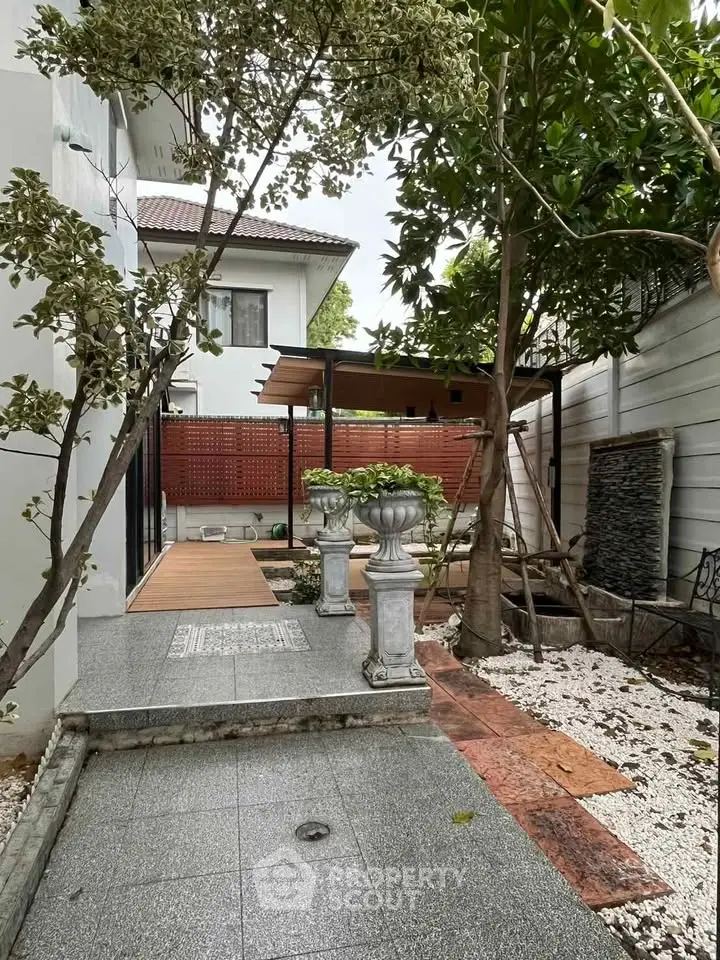 Charming garden view with elegant stone pathway and lush greenery in a serene residential setting.