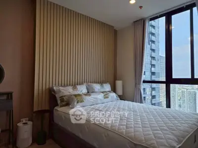 Modern bedroom with large window offering stunning city view in high-rise apartment.