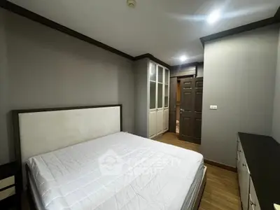 Spacious bedroom with modern design and ample storage in a stylish apartment.