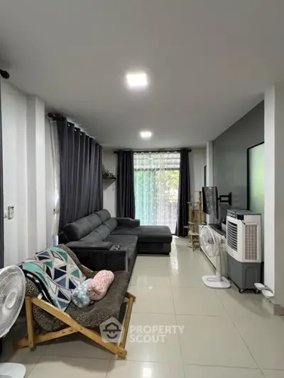 Spacious living room with modern decor and large windows for natural light