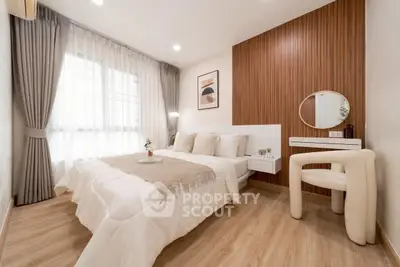 Modern bedroom with stylish decor and natural light, featuring a cozy bed and elegant furnishings.
