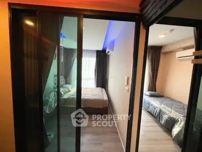 Modern bedroom with sliding glass doors and cozy lighting in a stylish apartment.
