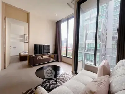 Modern living room with large windows and city view, featuring stylish furniture and open layout.