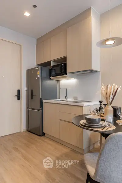 Modern kitchen with sleek cabinetry and dining area in stylish apartment