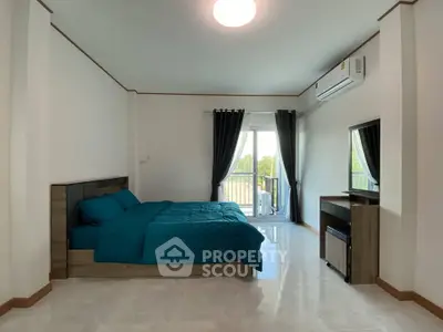 Spacious bedroom with modern decor and balcony access in a bright apartment.