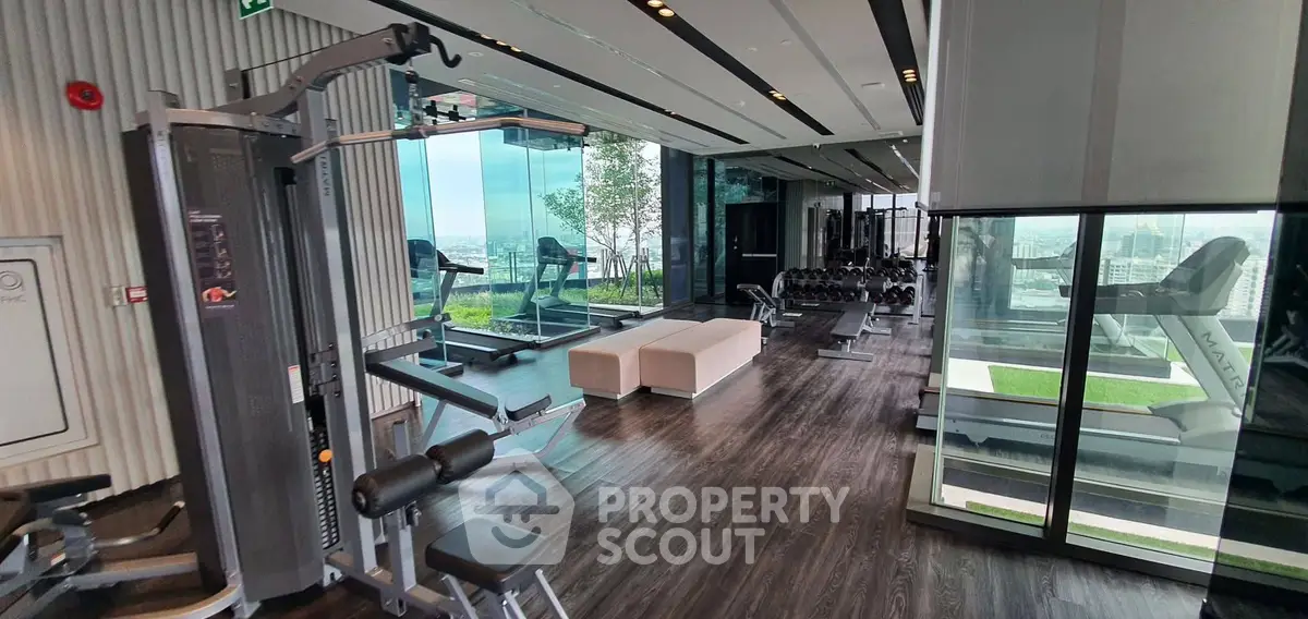Luxurious high-rise gym with panoramic city views and modern fitness equipment.