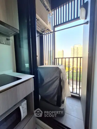 Compact balcony with city view and modern appliances in urban apartment