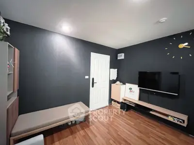 Modern living room with sleek black walls and wooden flooring