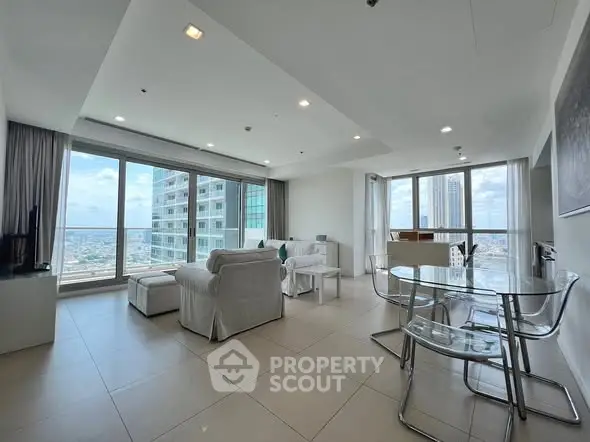 Spacious modern living room with panoramic city views and elegant furnishings.