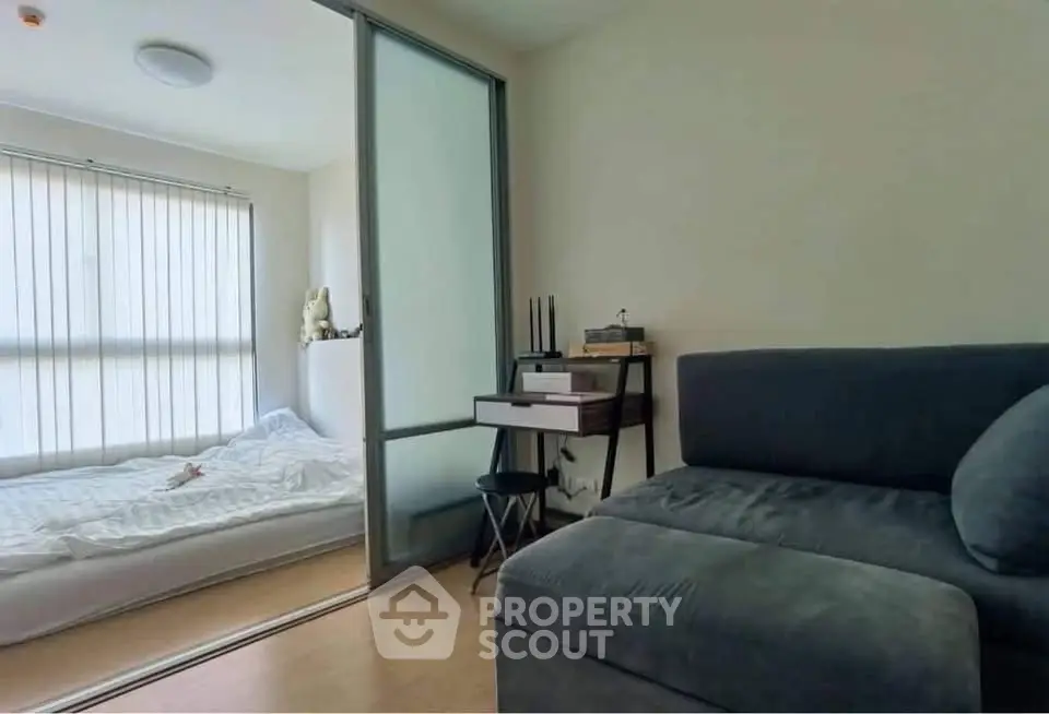 Cozy modern living room with sliding glass door to a minimalist bedroom, perfect for urban living.