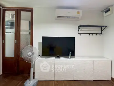 Modern living room with air conditioning, TV, and stylish storage unit