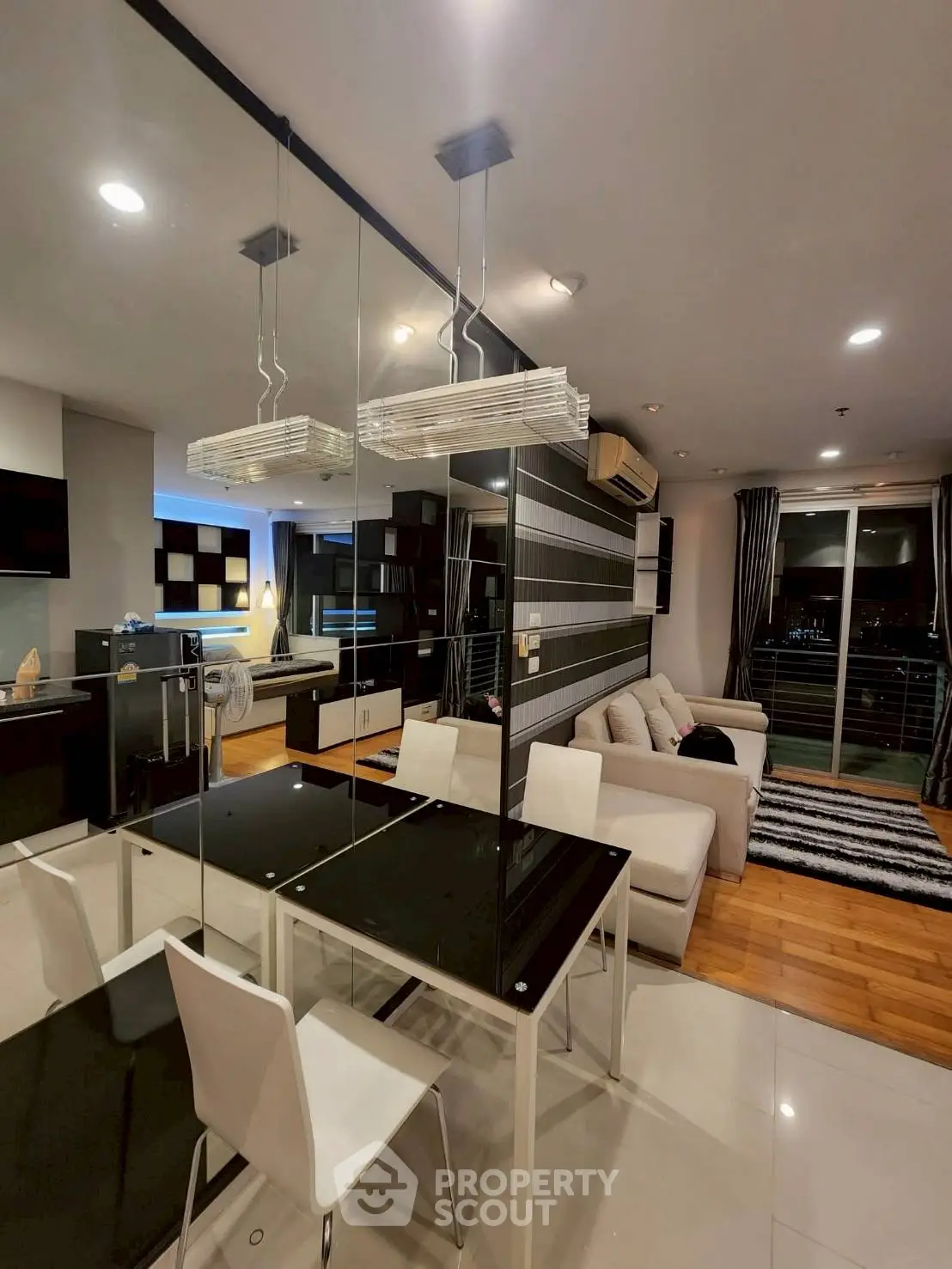 Modern living room with stylish decor and open layout, featuring a cozy sofa and elegant dining area.