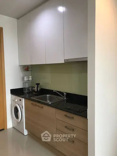 Modern kitchen with sleek cabinets and built-in washing machine
