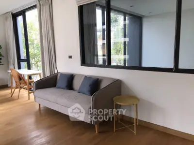 Modern living room with stylish sofa and large windows offering natural light.