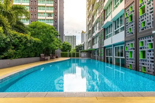 Luxurious condominium with a stunning outdoor pool and modern architecture, perfect for urban living.