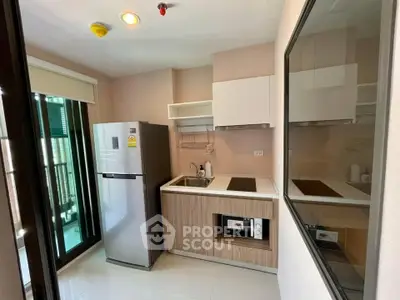 Modern kitchen with sleek appliances and balcony access in a stylish apartment.