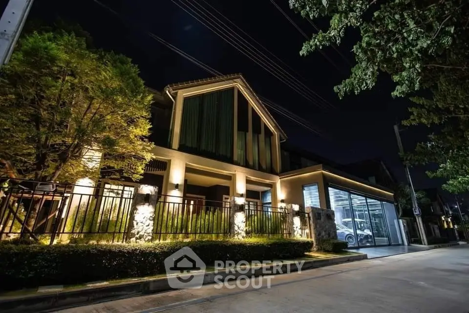 Stunning night view of a modern house with illuminated facade and lush greenery.