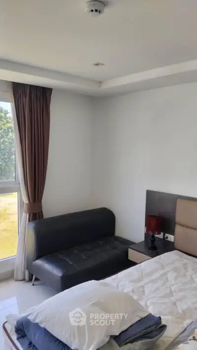 Cozy bedroom with natural light and modern furnishings, perfect for relaxation and comfort.