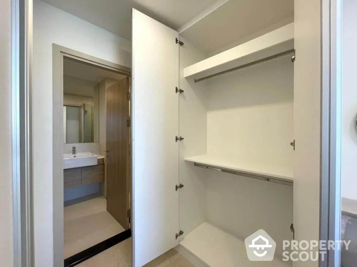 Spacious walk-in closet with modern bathroom view in luxury apartment