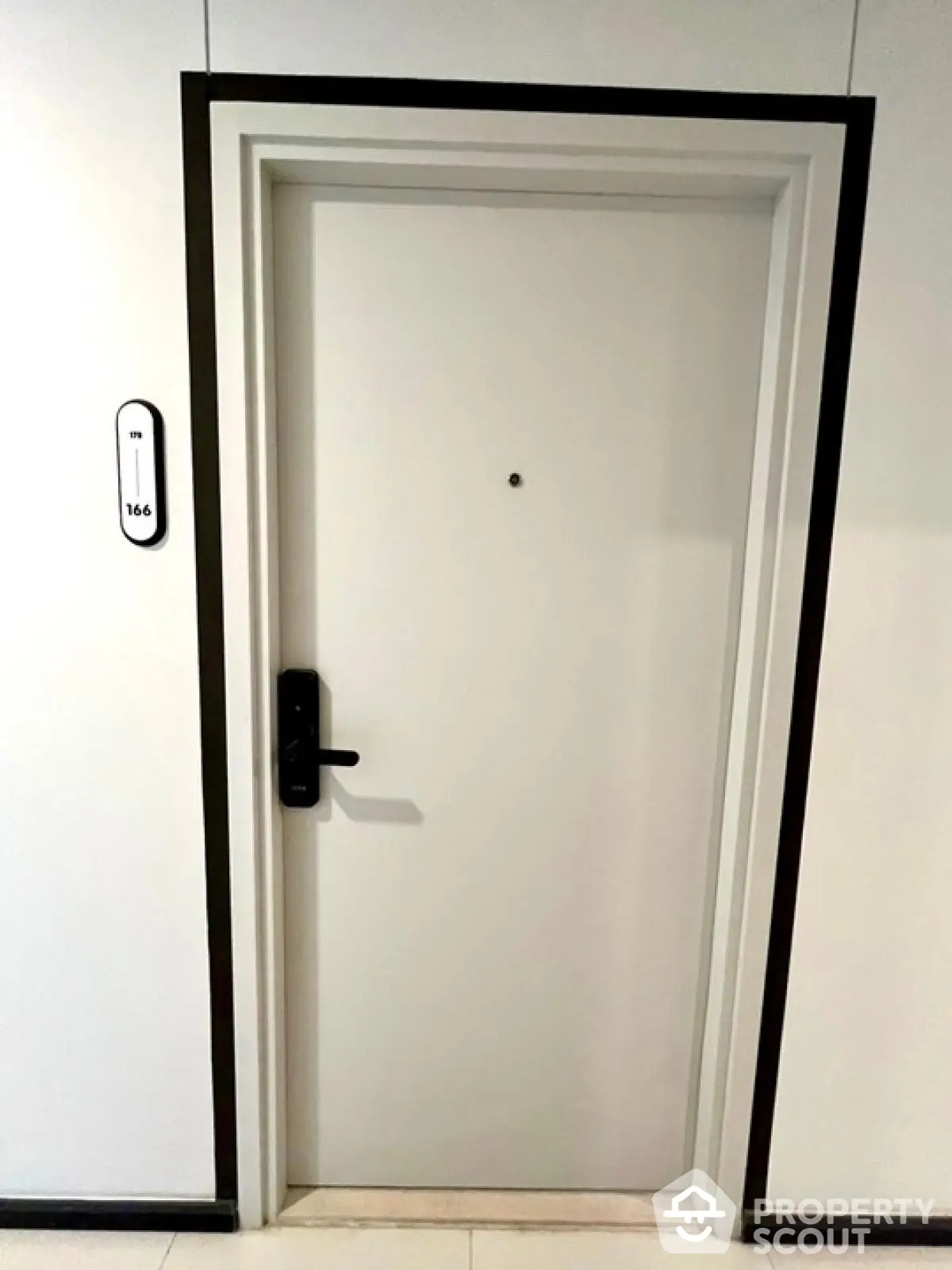 Modern apartment entrance door with sleek black handle and room number 166