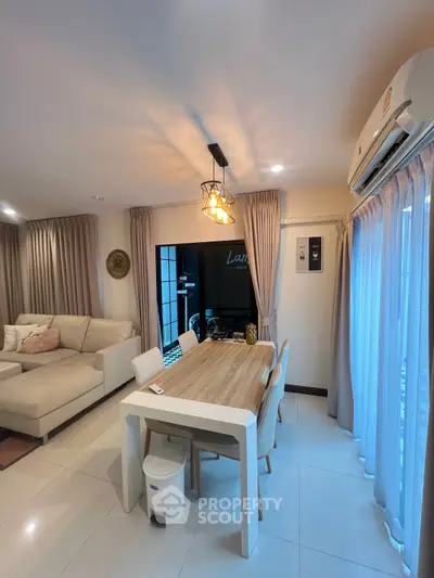 Modern living room with elegant dining area and stylish lighting in a cozy apartment.