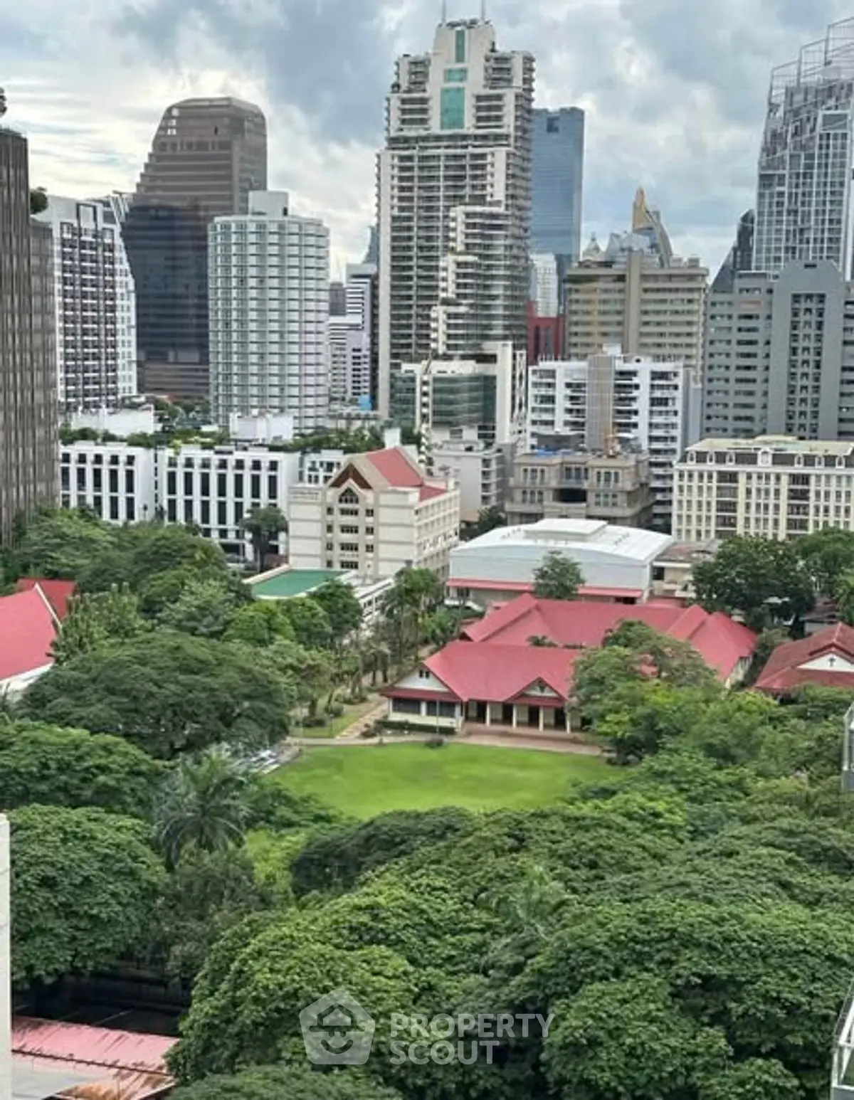 Stunning cityscape view with lush greenery and modern skyscrapers in the background.