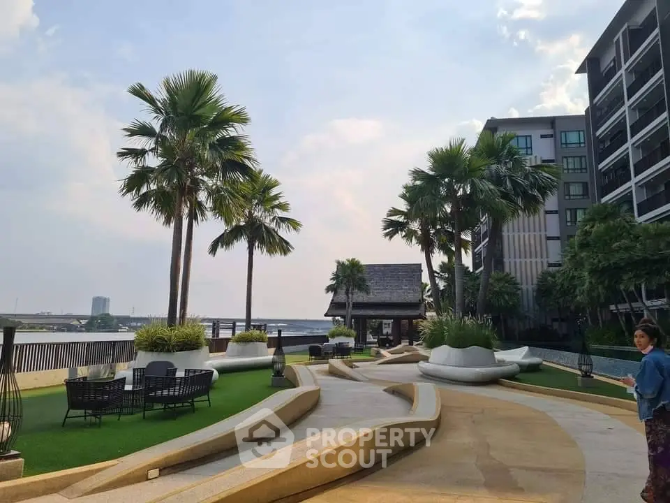 Luxurious riverside garden with palm trees and modern seating area