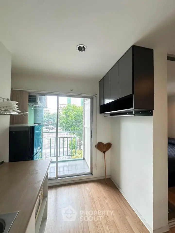 Modern kitchen with sleek cabinets and balcony view, perfect for urban living.