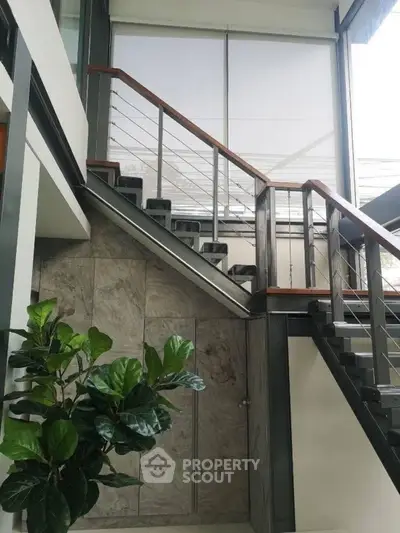 Modern staircase with sleek design and large window in contemporary home