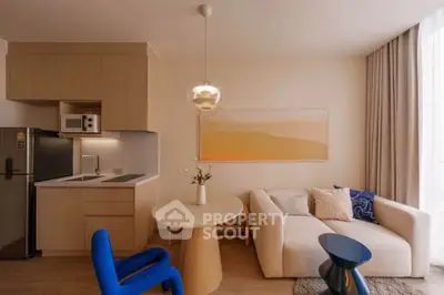 Modern living room with stylish furniture and compact kitchen in open layout apartment.