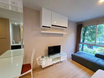 Modern living room with sleek furniture and large window offering a serene garden view.