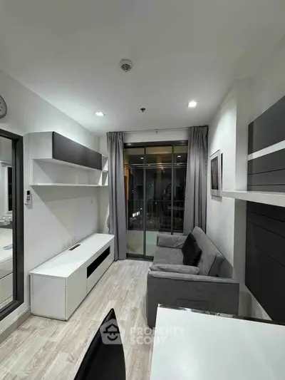 Modern living room with sleek furniture and large window in a stylish apartment.