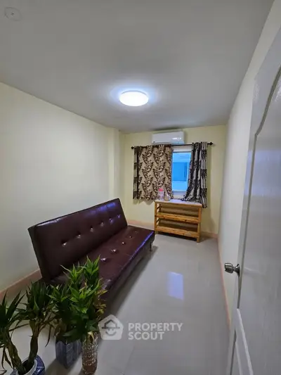 Cozy living room with modern sofa and window view, perfect for relaxation.