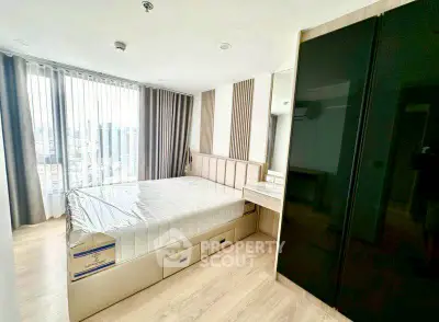 Modern bedroom with large windows and sleek furnishings in a high-rise apartment.