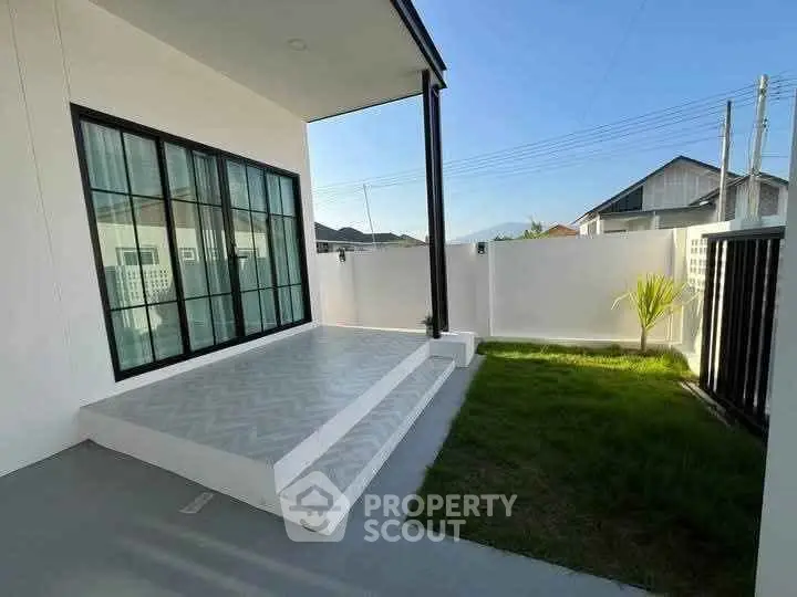 Modern home exterior with sleek patio and lush green lawn