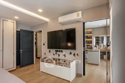 Modern living room with sleek design and large TV, showcasing contemporary interior style.